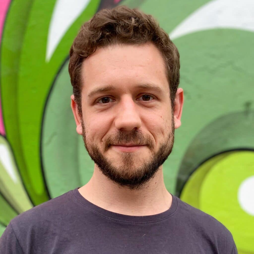 Rafael smiles in front of a street art canvas